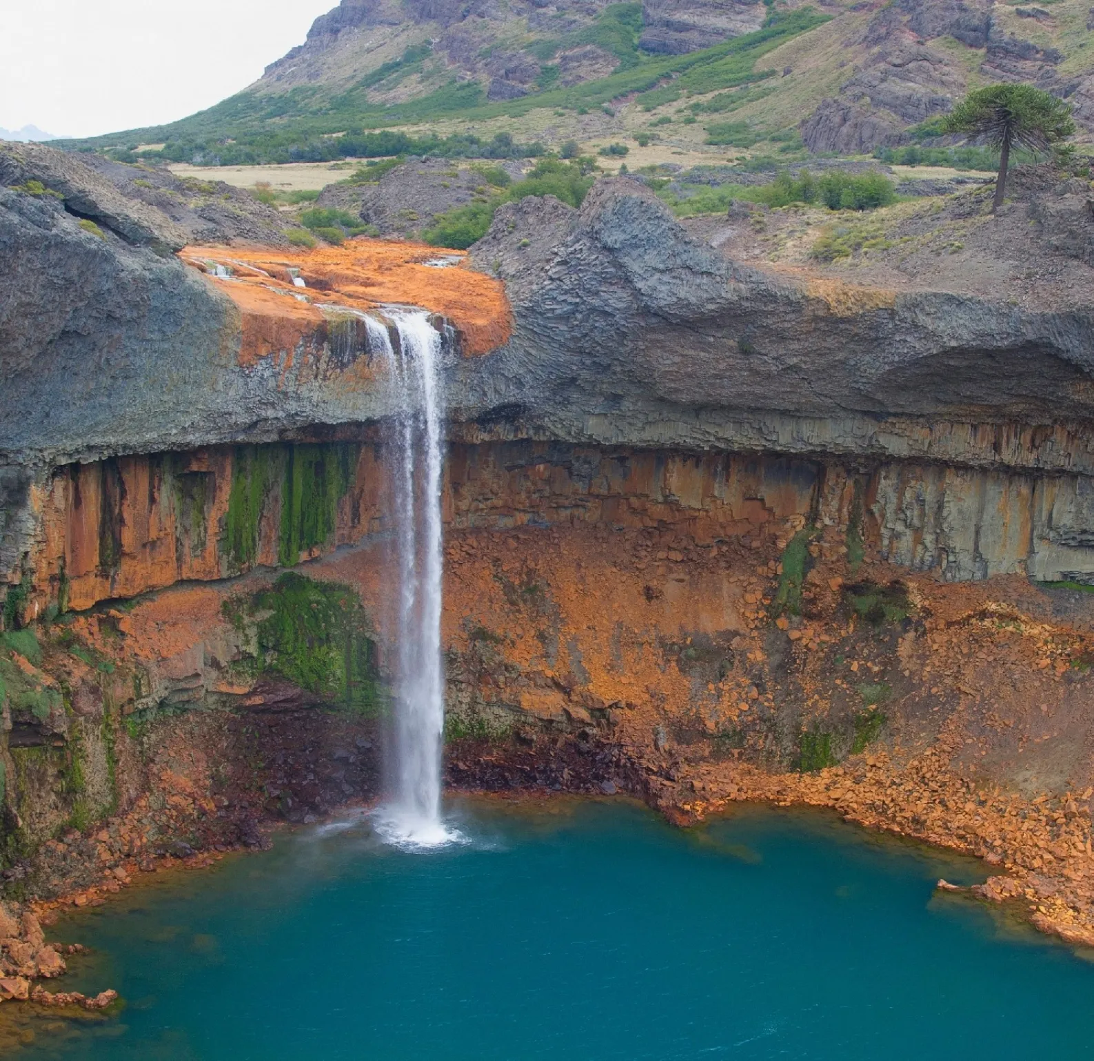 El Salto del Agrio cae entre rocas ocres sobre una laguna turquesa
