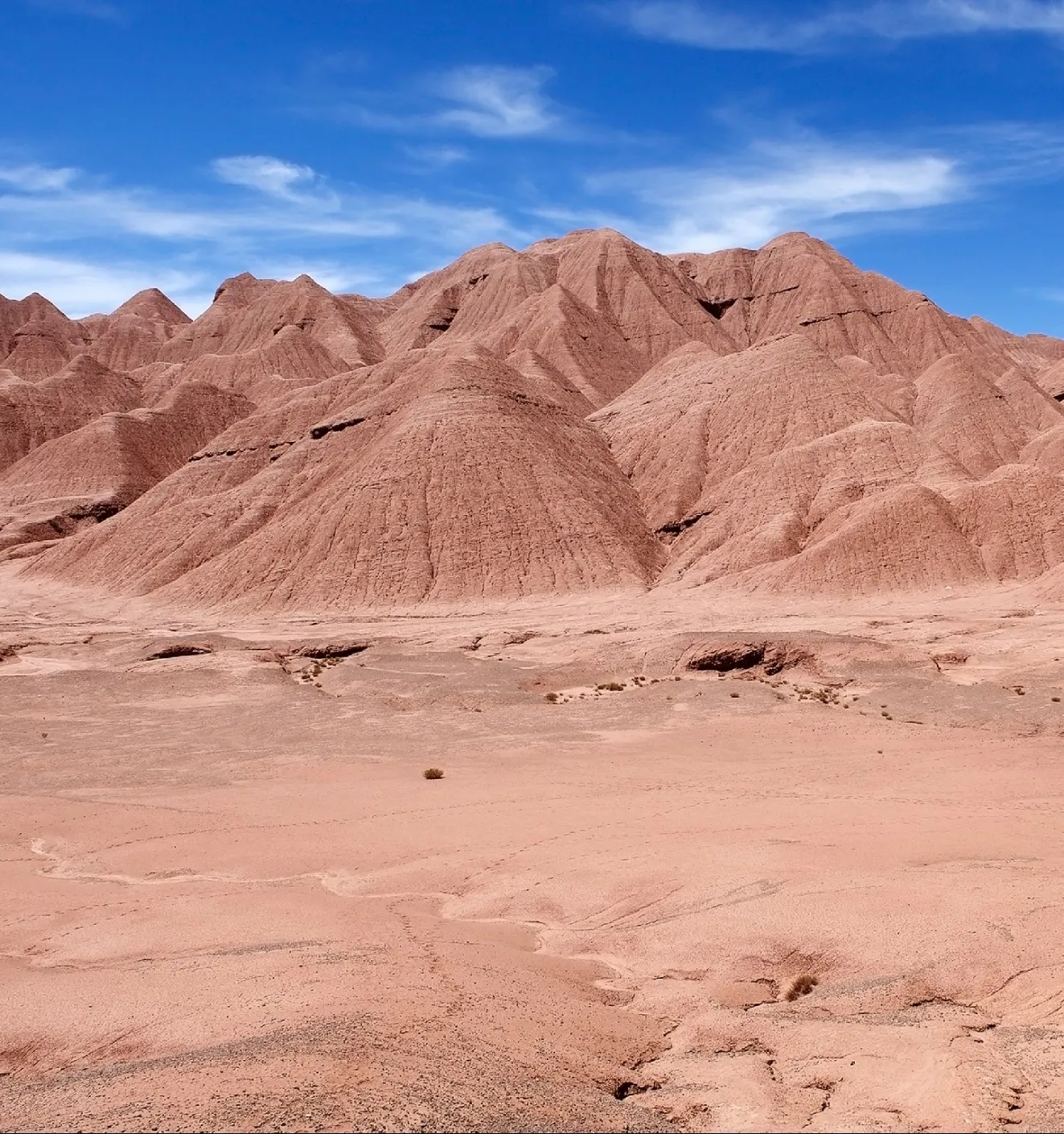Cerros y planicies de arcilla rojiza bajo un cielo azul