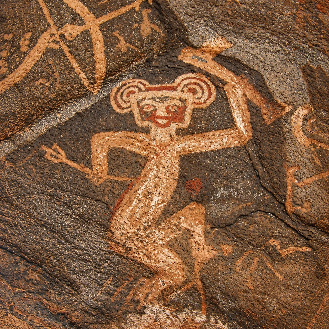Petroglifo de una figura danzante grabado en una roca antigua